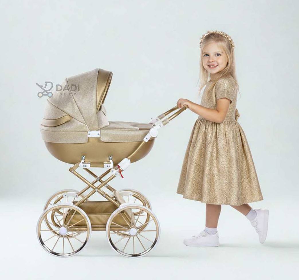 Dziewczynka w sukience księżniczki prowadzi złoty wózek dla lalek Junama Dolce Mini z regulowaną rączką – idealny prezent na święta